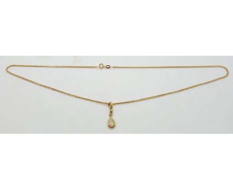 An 18ct gold pendant set with an opal and two diamonds on a 9ct gold chain