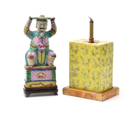 A Chinese Export 'Famille Rose' figural pricket-stick, early 19th century, modelled as a smiling immortal with scrolling bear