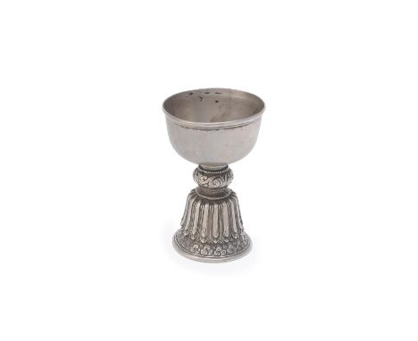 A Tibetan or Himalayan metal butter lamp, 19th century, with lotus decorated base and the rim of the cup with horizontal band