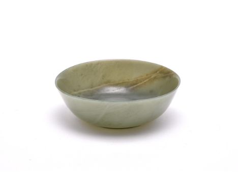 A Chinese jade spinach-green bowl, Qing Dynasty, with rounded sides, the base incised with a four-character jiaqing nianzhi m