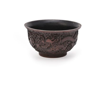 A Chinese carved red and black lacquer 'Dragon' bowl, late Qing/Republican period,  supported on a short circular foot and is