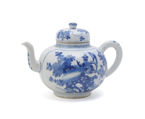 A Chinese blue and white large teapot and cover, Kangxi, the globular painted with two shaped panels enclosing a bird perched