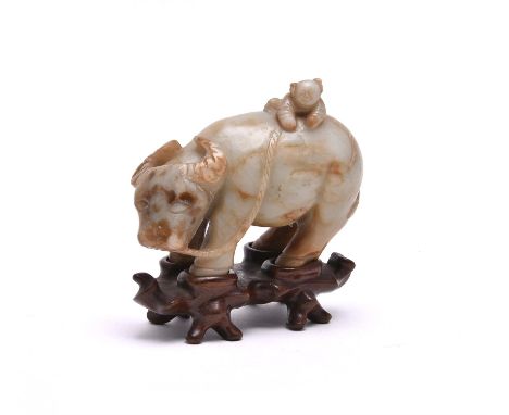 A Chinese jade 'Buffalo and boy' group, the standing buffalo carved with a boy playfully clambering onto its back, the stone 