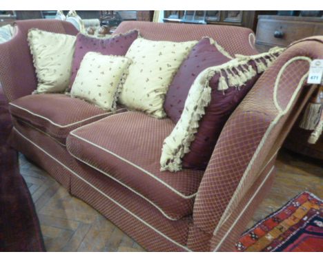 Knole sofa upholstered in  a red and gold diamond pattern fabric with satin scatter cushions 