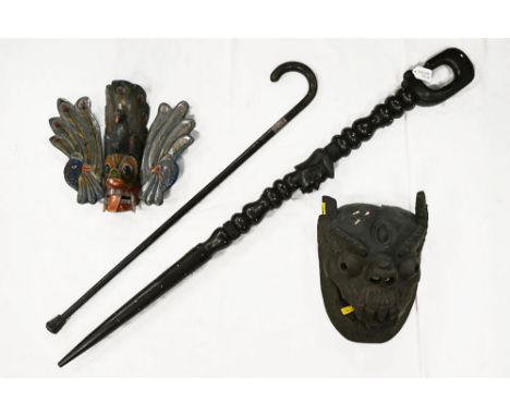 Hardwood tribal carved walking stick, two wooden face masks and ebonised silver collared walking stick