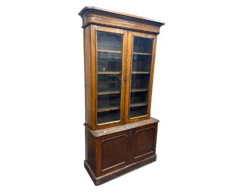 Victorian mahogany bookcase, projecting cornice over pair of glazed doors enclosing four shelves, the base fitted with double