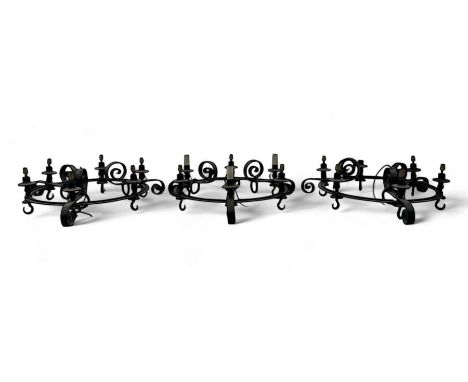 Set of three mid-20th century wrought iron six-light chandeliers, each with a circular frame with scrolled arms, faux candle 