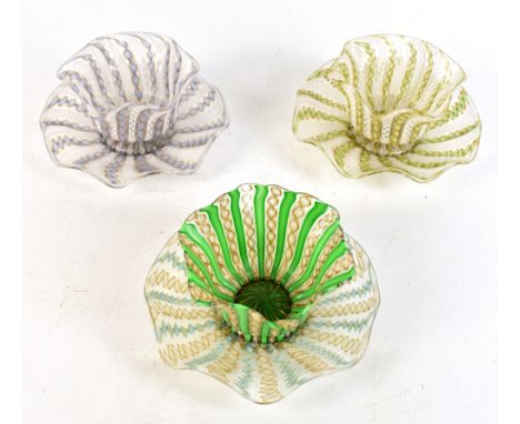 PAOLO VENINI ZANFIRICO FOR MURANO GLASS; three handkerchief bowls raised on associated stands, with lattice canes, height of 