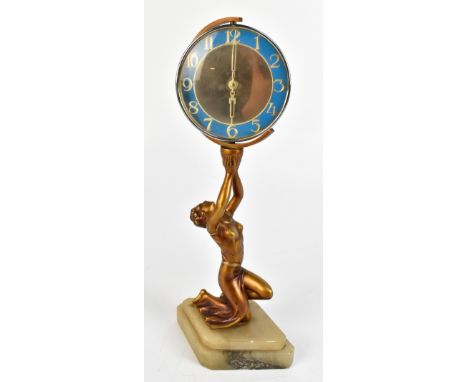 An Art Deco gilt spelter figural desk clock representing a kneeling lady supporting a circular chrome mounted clock dial with