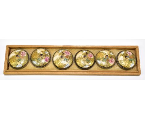 A cased set of six Japanese Meiji period Satsuma buttons, each decorated with an exotic bird and with white metal backings in