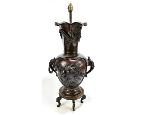 A Japanese Meiji period bronze twin handled lamp, relief decorated with stylised birds and prunus flowers, originally raised 