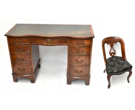 A reproduction mahogany veneered serpentine fronted kneehole desk, with green leather inset top above an arrangement of nine 