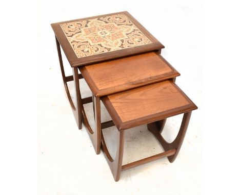 G-PLAN; a mid-20th century teak framed nest of three graduated coffee tables, the larger table inset with four ceramic tiles.