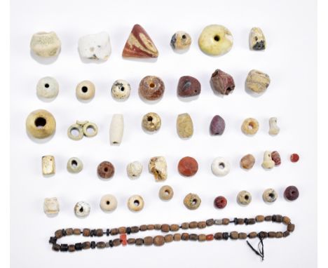 A group of ancient ceramic, glass and stone jewellery beads of varied size and form.Provenance: a private UK collection assem