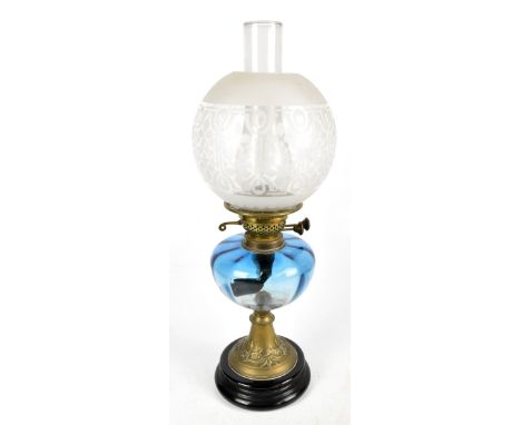 A late 19th/early 20th century oil lamp with etched glass shade, clear chimney and blue glass reservoir, the burners stamped 