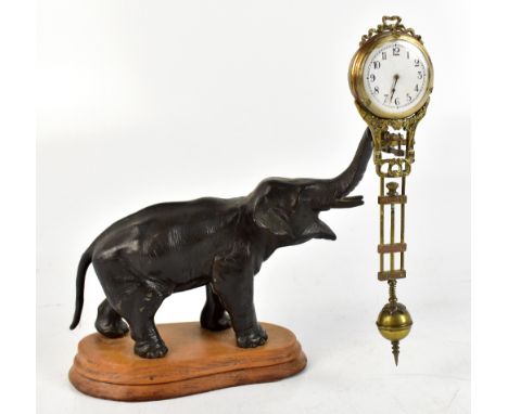 A Japanese Meiji period bronzed elephant mounted on wooden base, now set as a mystery clock, the timepiece with white enamell