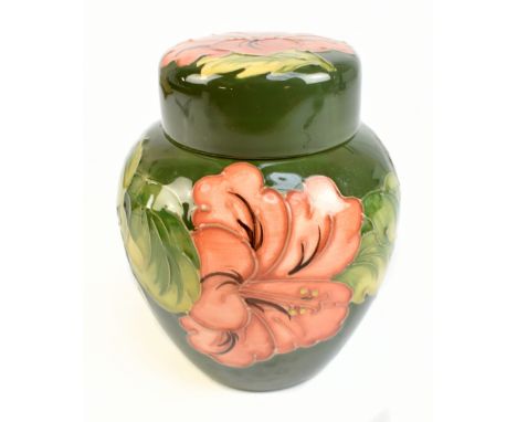 MOORCROFT; a ginger jar and cover decorated in the 'Hibiscus' pattern on a green ground, green signature to base, height 16cm