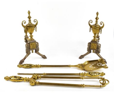 A pair of late 19th century Adam-style brass fire dogs, both with Classical urns with ring handles, above outswept hoof feet,