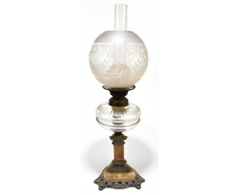 An early 20th century marble and cast metal oil lamp with clear glass reservoir and frosted shade, raised on triangular metal