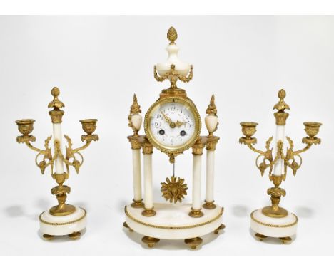 A late 19th century French gilt brass and alabaster mantel clock garniture, the circular dial set with Arabic numerals raised