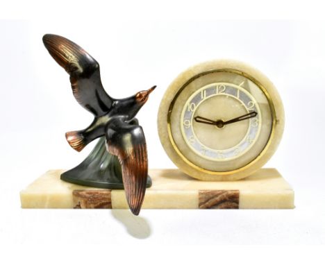 A French Art Deco alabaster mantel clock with bronzed metal surmount depicting a seagull in flight, the circular dial with Ar
