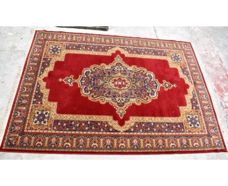 A large Middle Eastern rug with stylised decoration on red ground, approx 287 x 200cm.Additional InformationSome light genera
