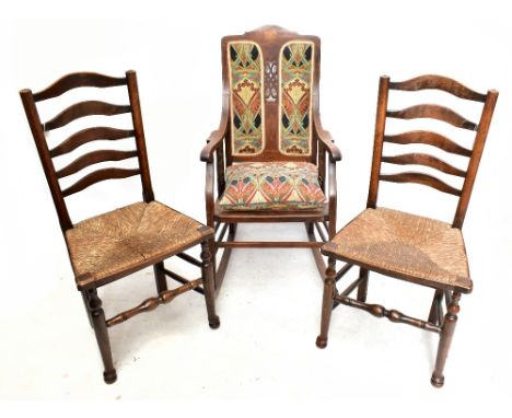 An early 20th century inlaid mahogany cane seated rocking chair, upholstered with Liberty material to the back, with a matchi