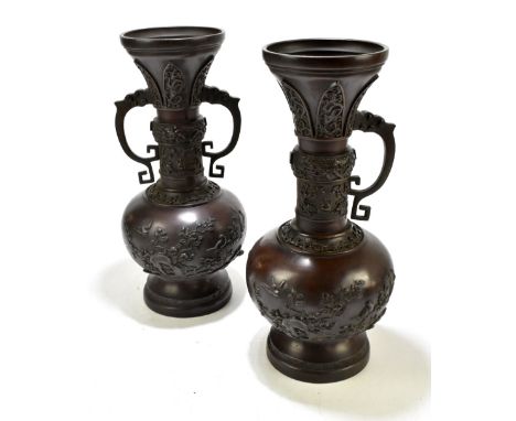 A pair of Japanese Meiji period bronze twin handled vases (one handle loose and detached) with floral decoration in relief, o
