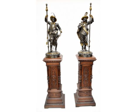 A large and impressive pair of late 19th century bronzed mixed-metal lamps modelled as Cavaliers, each set upon an oak leaf a