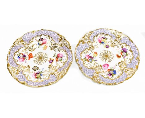 COALPORT; a pair of early 19th century porcelain gilt heightened and pierced dessert plates painted in enamels with floral de