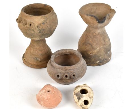 Five ancient earthenware oil lamps comprising three Javanese Mahapahit Kingdom partially black glazed examples, two with thre