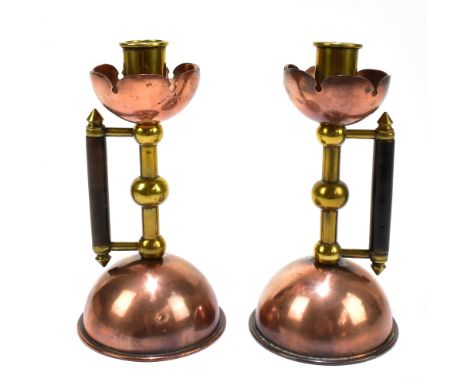 ATTRIBUTED TO CHRISTOPHER DRESSER FOR BENHAM &amp; FROUD; a pair of Arts &amp; Crafts brass and copper candlesticks, with sta