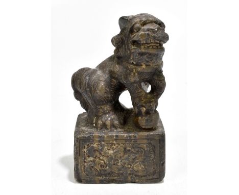 A Chinese carved stone shishi on scroll decorated base, height 18.5cm.Additional InformationSome rubbing and tiny chips to th