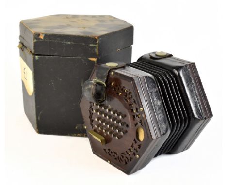A late 19th century fifty six key concertina with pierced rosewood ends, lacking maker's name and number to oval aperture, in