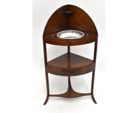 A late George III mahogany and line inlaid corner washstand with single drawer to the central shelf, raised on outswept squar