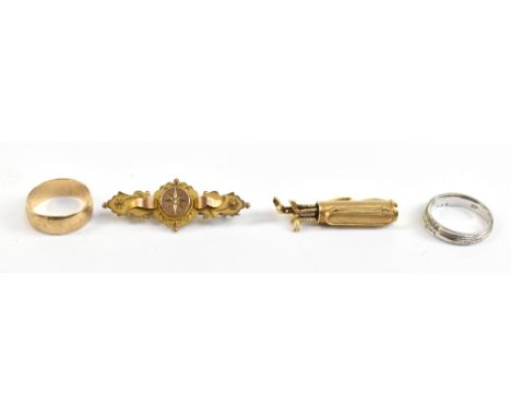 A selection of 9ct yellow gold to include a Victorian bar brooch with central white stone, a novelty charm in the form of gol