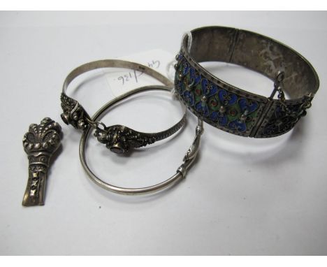 A Middle Eastern Bangle, highlighted in enamel; together with a collet set bangle, stamped "925", a dolphin detail bangle etc