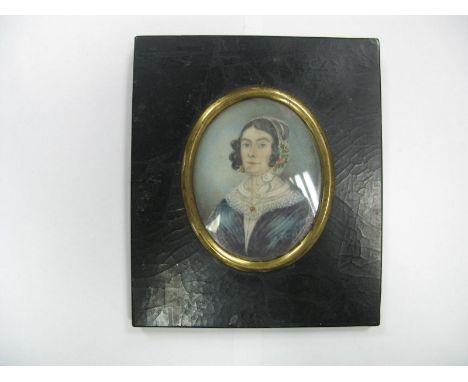 A XIX Century Portrait Miniature, young woman attired in lace bonnet and blue dress with lace collar, original paper label Th