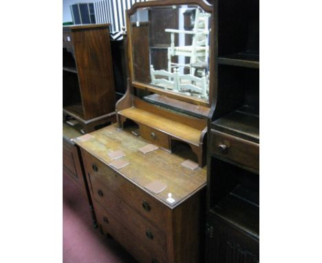 An Early XX Century Oak Dressing Table, with a central mirror, over jewel drawer, base with three long drawers on bracket fee