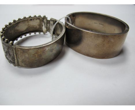 A Wide Hallmarked Silver Bangle, leaf scroll engraved, hinged to snap clasp; together with another, of Aesthetic design. 