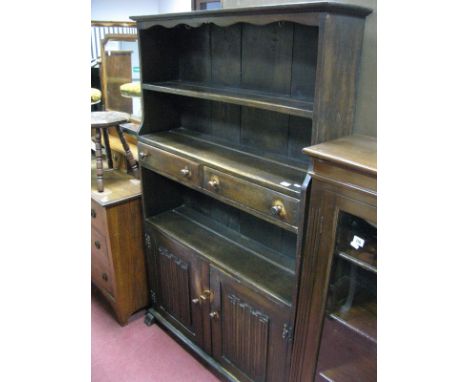 A XX Century Oak Dresser, with a shaped freeze, open shelf over two small central drawers above an open shelf, two panelled l