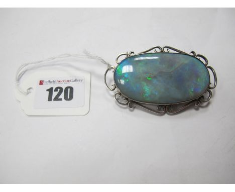 A Large Opal Brooch, the oval panel collet set within openwork scroll border (closed back setting), overall width 7cms. 