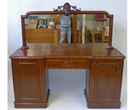 A Victorian mahogany twin pedestal mirror back sideboardThe central drawer flanked by two panelled doors, raised on plinth ba