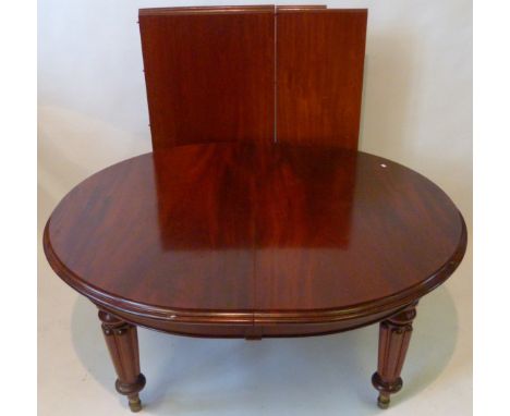 A Victorian mahogany wind out action extending dining tableRaised on turned carved supports terminating on brass stops, width