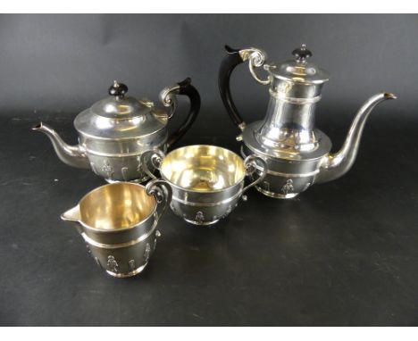 An Edward VII four piece tea and coffee setComprising coffee and teapot with hinged lids and ebonised handles, together with 