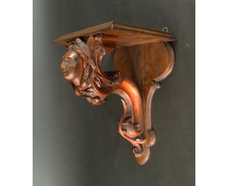 An Edwardian mahogany wall bracket Having central carved decoration depicting a female bust, length 33cm 