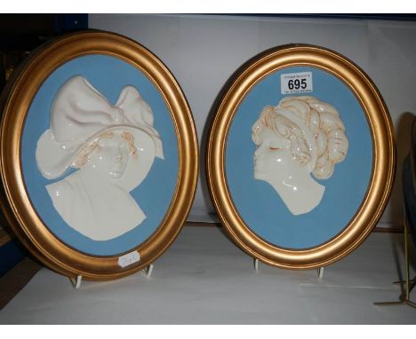 A pair of oval plaster portrait plaques.