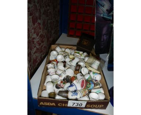 A tray of thimbles and a thimble display shelf,