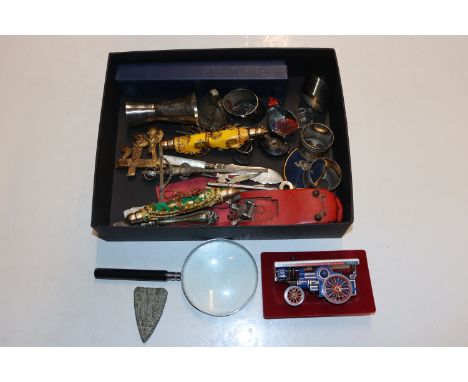 A box of various small sundry items to include magnifying glass, Dinky toy fire engine, napkins rings, a shot measure etc.