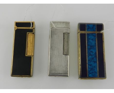 A Dunhill chassis gold plated and black rollagas lighter, together with another Dunhill white metal rollagas lighter and a Co